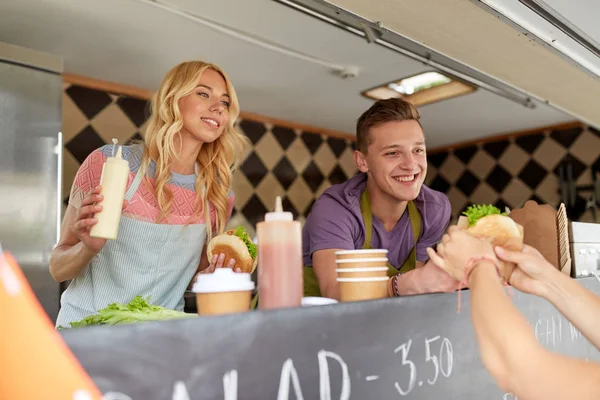 Ευτυχισμένος πωλητές που εξυπηρετούν τους πελάτες στο φορτηγό τροφίμων — Φωτογραφία Αρχείου