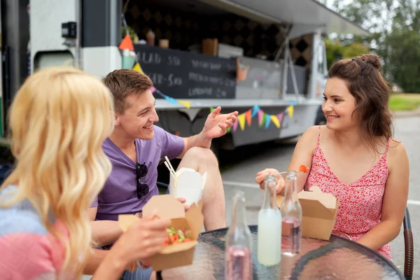 Amigos felices con bebidas comiendo en camión de comida —  Fotos de Stock