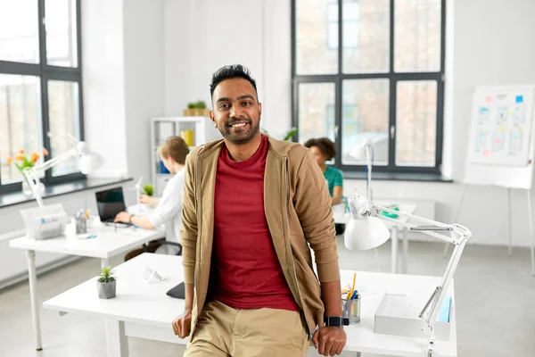 Uomo indiano sorridente con orologio intelligente in ufficio — Foto Stock