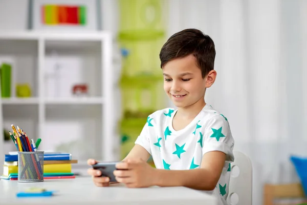 Niño feliz con teléfono inteligente en casa —  Fotos de Stock