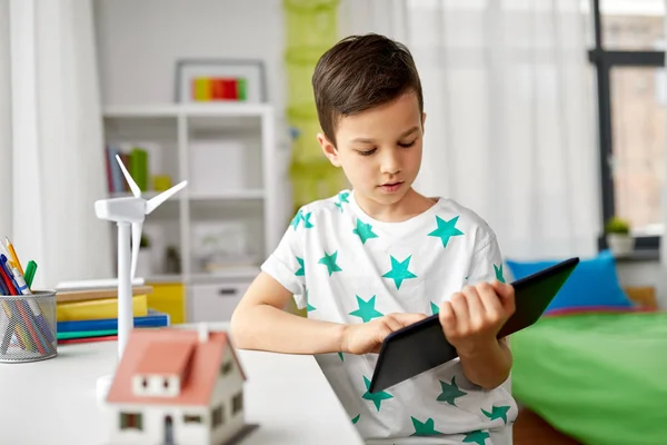 Junge mit Tablet, Spielzeughaus und Windrad — Stockfoto