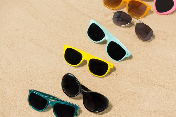 Lunettes de soleil différentes sur sable de plage — Photo