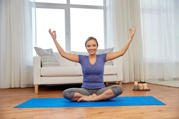 Mulher sorridente meditando em lótus posar em casa — Fotografia de Stock