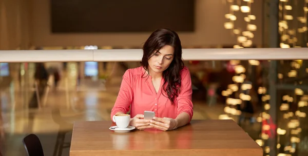 Femme avec café et smartphone au restaurant Photo De Stock