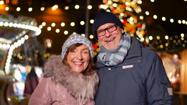 Feliz pareja de ancianos sonriendo en el mercado de Navidad — Vídeos de Stock