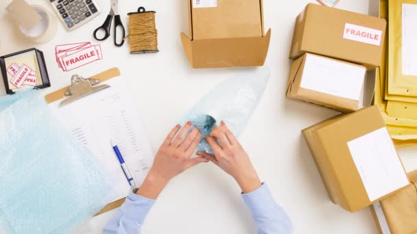 Taza de embalaje de mujer a caja de paquete en la oficina de correos — Vídeos de Stock