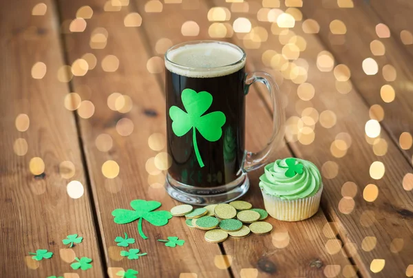 Τριφύλλι σε ποτήρι μπύρα, πράσινο cupcake και κέρματα — Φωτογραφία Αρχείου