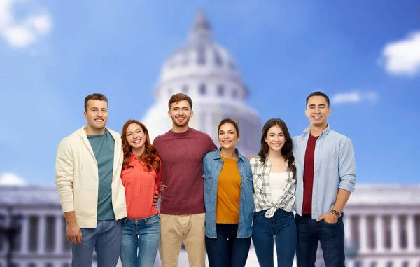 Grupp av leende vänner över capitol byggnaden — Stockfoto