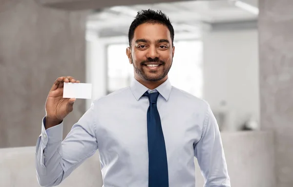 Indian businessman with business card over office — Stock Photo, Image