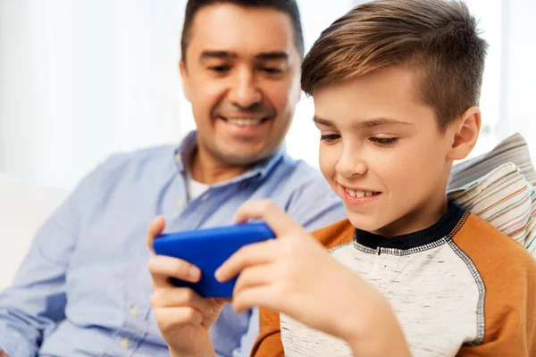 Glücklicher Vater und Sohn mit Smartphone zu Hause — Stockfoto