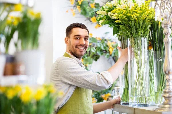 Florista feliz homem definindo flores na loja de flores — Fotografia de Stock