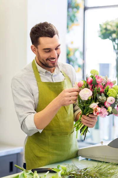 Fiorista sorridente che fa mazzo al negozio di fiori — Foto Stock