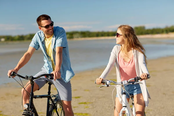 Gelukkige jonge paar paardrijden fietsen aan zee — Stockfoto