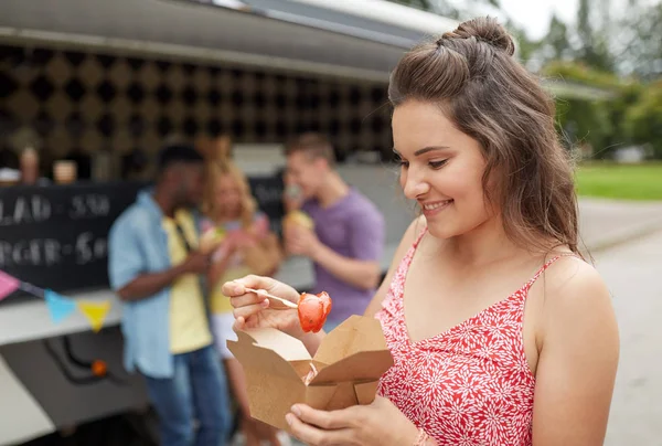 Happy woman with wok and friends at food truck — Stock Photo, Image