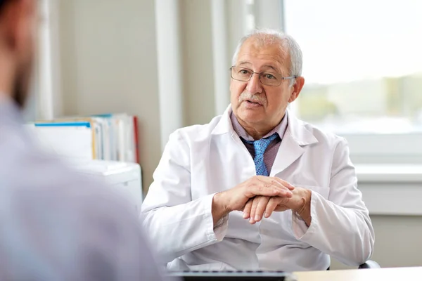 Medico anziano che parla con un paziente di sesso maschile in ospedale — Foto Stock
