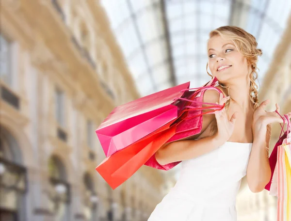 Vrouw met boodschappentassen over mall achtergrond — Stockfoto