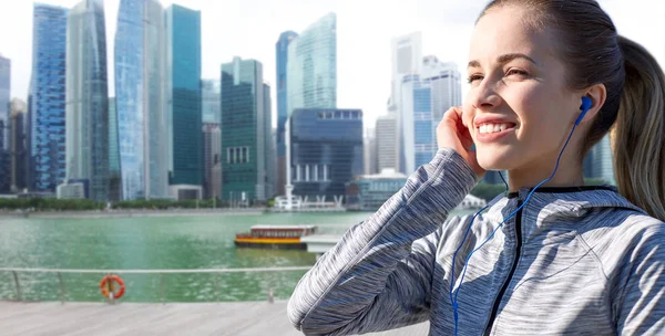 Mujer feliz con auriculares sobre la ciudad de Singapur — Foto de Stock