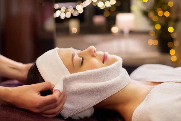 Vrouw met gezicht massage met handdoek in spa — Stockfoto