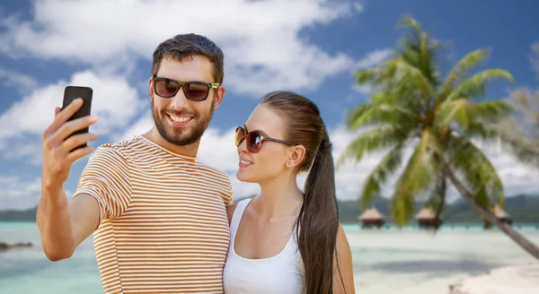 Happy couple taking selfie by smartphone on beach — Stock Photo, Image