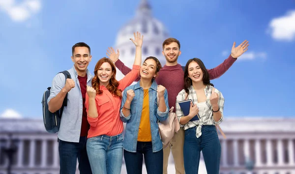 Happy students celebrating over capitol building — Stock Photo, Image
