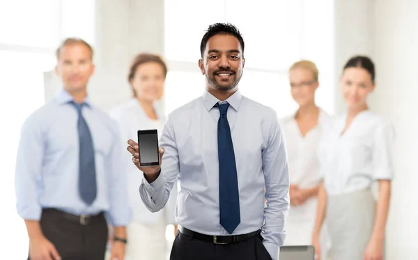 Uomo d'affari indiano con smartphone in ufficio — Foto Stock