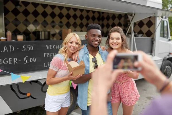 Uomo scattare foto di amici che mangiano al camion cibo — Foto Stock