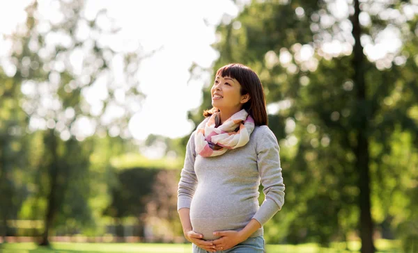 Feliz embarazada asiático mujer en parque — Foto de Stock