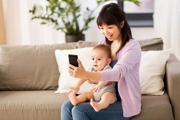 Aziatische moeder met baby zoon nemen selfie thuis — Stockfoto