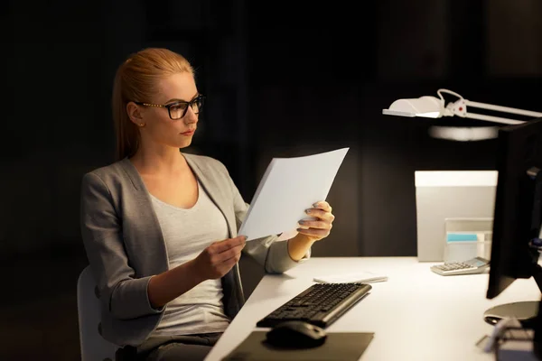 Affärskvinna med papper som arbetar på natten kontor — Stockfoto