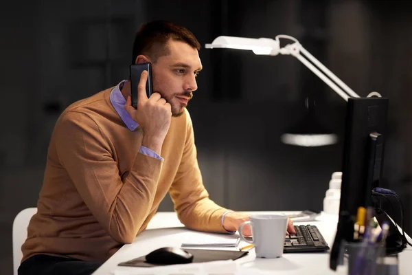 Hombre de negocios llamando a sartphone en la oficina nocturna — Foto de Stock