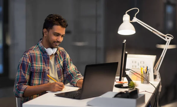 Homme créatif avec ordinateur portable travaillant au bureau de nuit — Photo