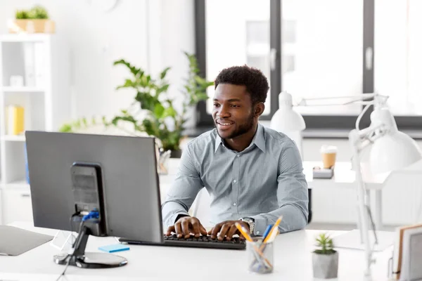 Empresário africano com computador no escritório — Fotografia de Stock