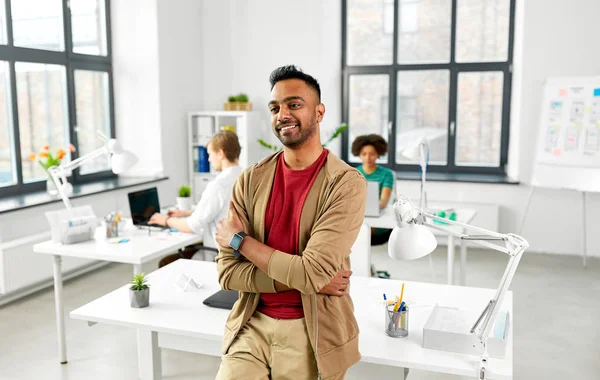 Uomo indiano sorridente con orologio intelligente in ufficio — Foto Stock