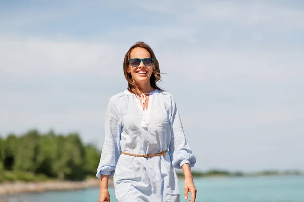 Szczęśliwy uśmiechający się kobieta spaceru wzdłuż plaży latem — Zdjęcie stockowe