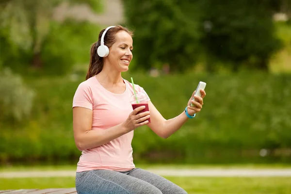 Kvinna med smartphone och skaka lyssnar på musik — Stockfoto