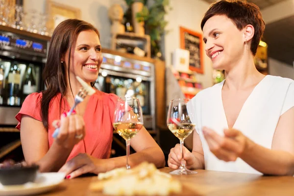 Women eating snacks at wine bar or restaurant — Stock Photo, Image