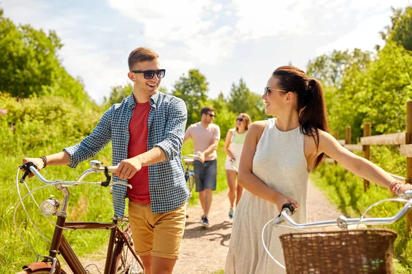 Счастливая пара с велосипедами в летнем парке — стоковое фото