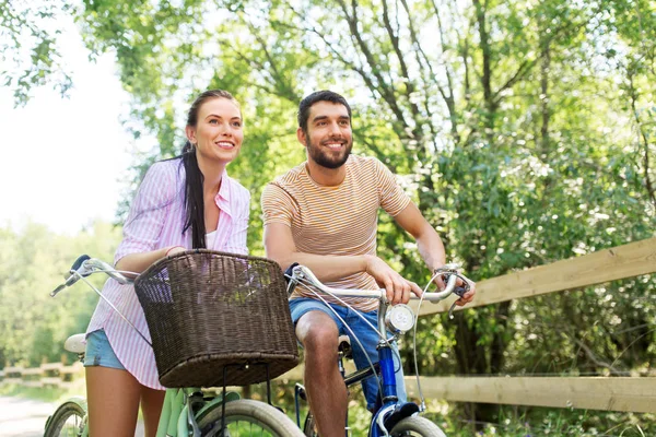 Coppia felice con biciclette al parco estivo — Foto Stock