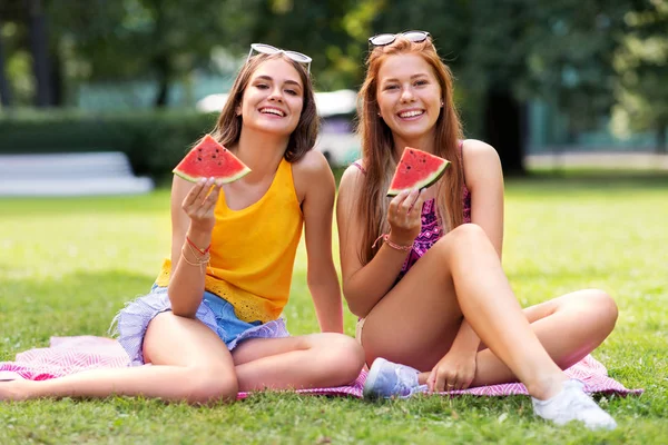 Tonårsflickor som äter vattenmelon på picknick i parken — Stockfoto