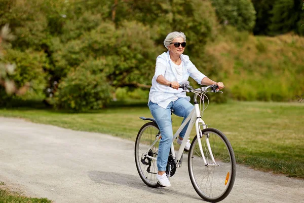 夏の公園で幸せな先輩女乗って自転車 — ストック写真