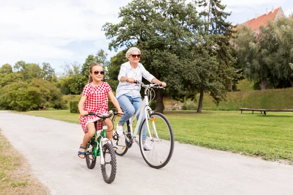 Büyükanne ve torunu parkta Bisiklete binme — Stok fotoğraf