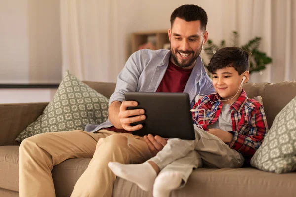 stock image father and son listening to music on tablet pc