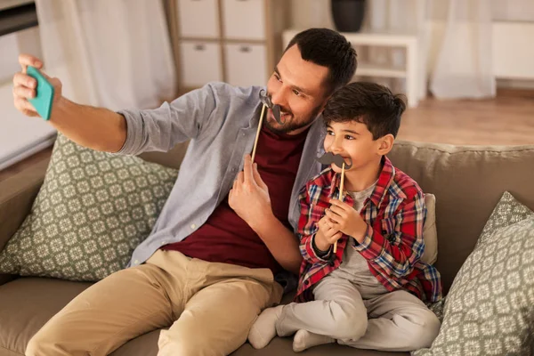 Pai e filho tomando selfie em casa — Fotografia de Stock