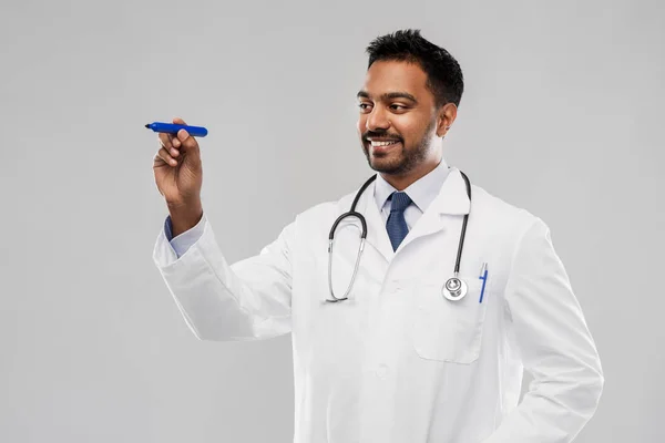 Sorridente índio masculino médico com marcador — Fotografia de Stock