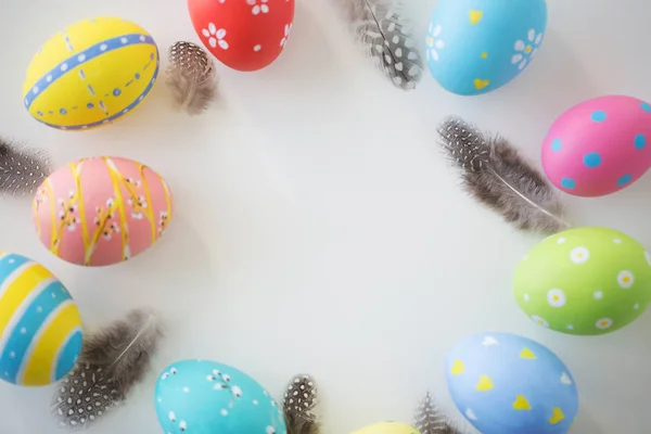 Primer plano de huevos y plumas de Pascua de colores — Foto de Stock