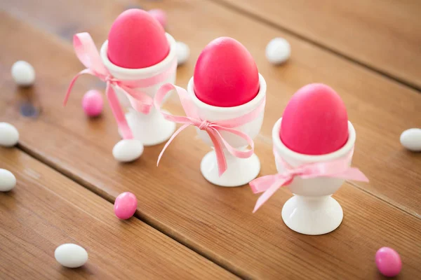 复活节彩蛋在持有人和糖果滴在桌子上 — 图库照片
