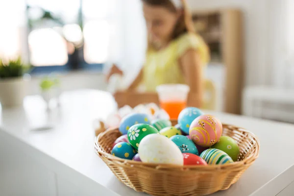 Colored easter eggs and girl on background at home — Stock Photo, Image
