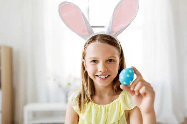 Щаслива дівчина з кольоровим пасхальним яйцем вдома — стокове фото