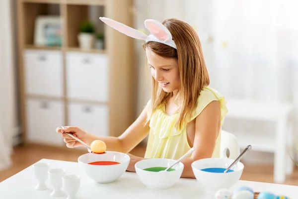 Menina colorir ovos de Páscoa por tintura líquida em casa — Fotografia de Stock