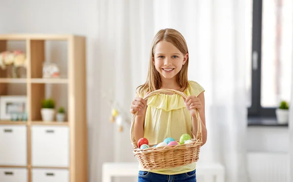 Felice ragazza con cesto di uova di Pasqua a casa — Foto Stock